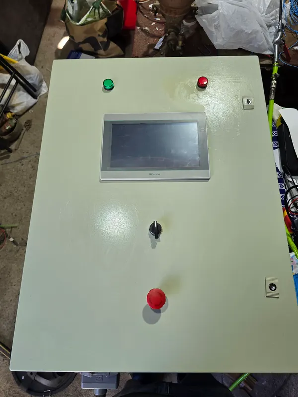 Panel HMI WECON instalado en un gabinete con pulsadores y parada de emergencia